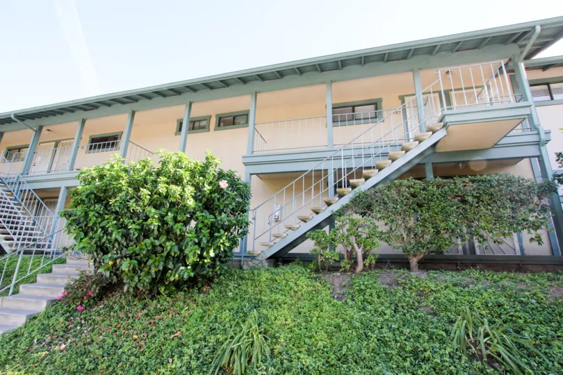 A simple, low-rise housing in the Pacific Woodlands community with an exterior staircase.