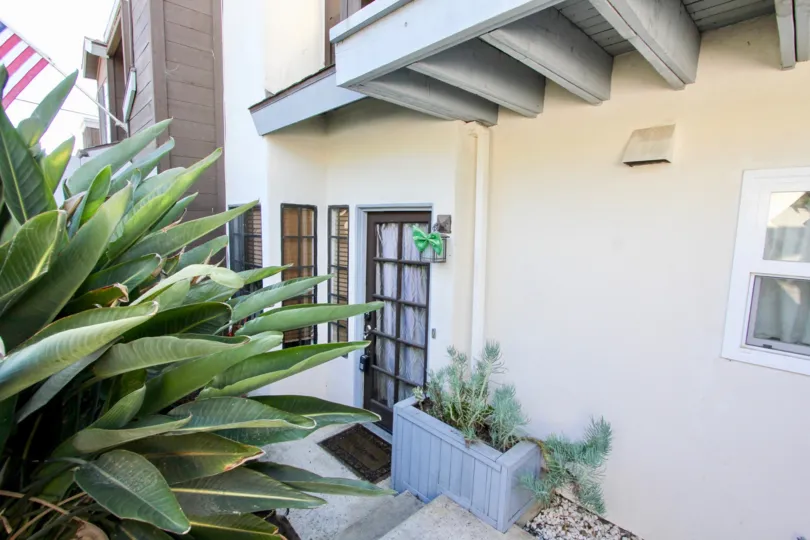 A sunny day in the Pacifica Townhomes with residential building and plants.