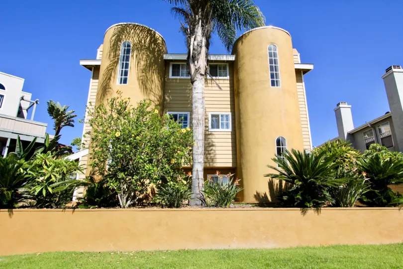 A reed ave in the Pacific Beach with pillar like buildings and trees