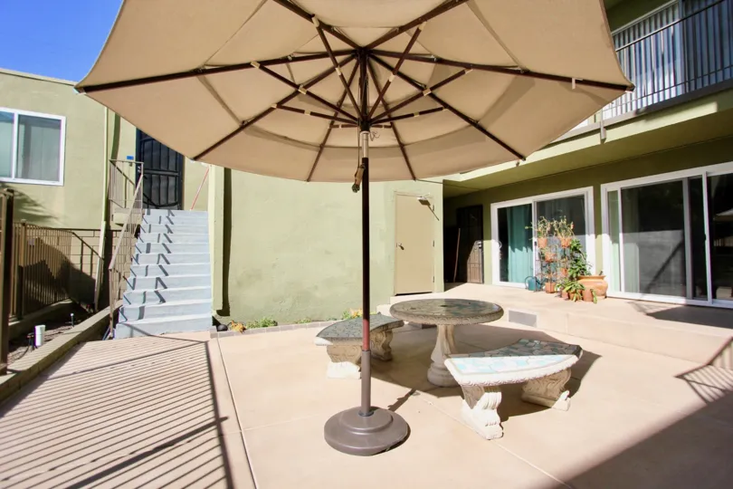 Umbrella next to a cement bench that is surrounded by condos in Regency Condos at Pacific Beach CA