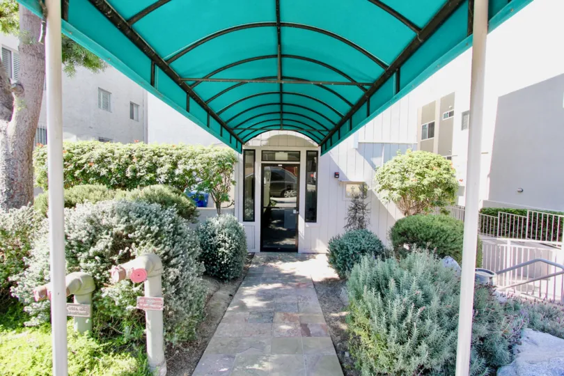 enterance with a stone pathway and bushes and grass on the either sides for a fresh feel
