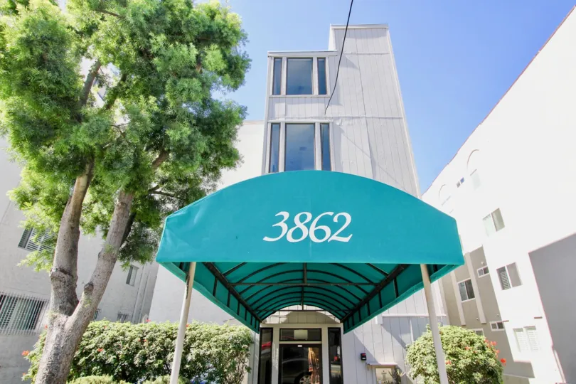 A sunny day in the area of Riviera Sands. outside, house number, condo, tree, high rise