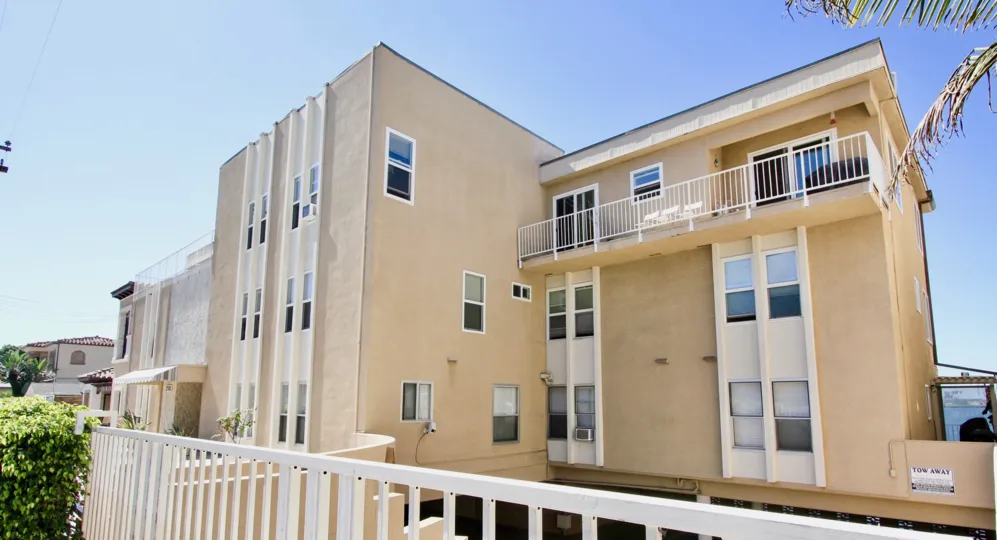 A sunny day in the area of Riviera Terrace, white fence, balcont, trees, windows, high rise