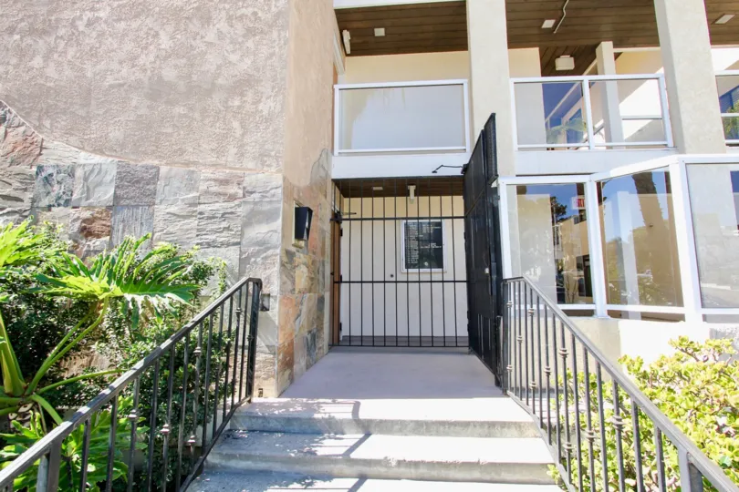 An entrance to a contemporary housing in the Riviera Villas community with glass railings.