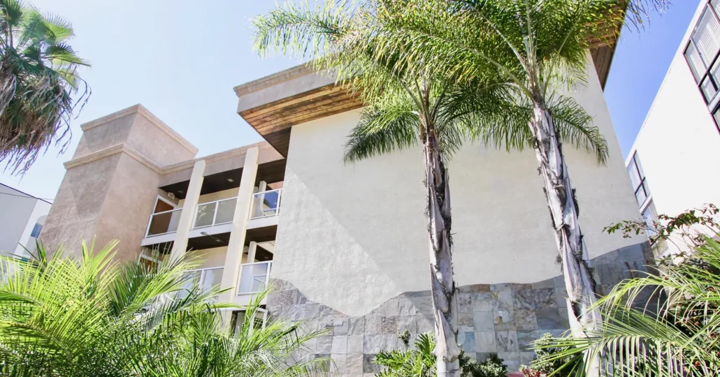 Bright sunny day with palm trees besides a villa in Riviera Villas of Pacific Beach