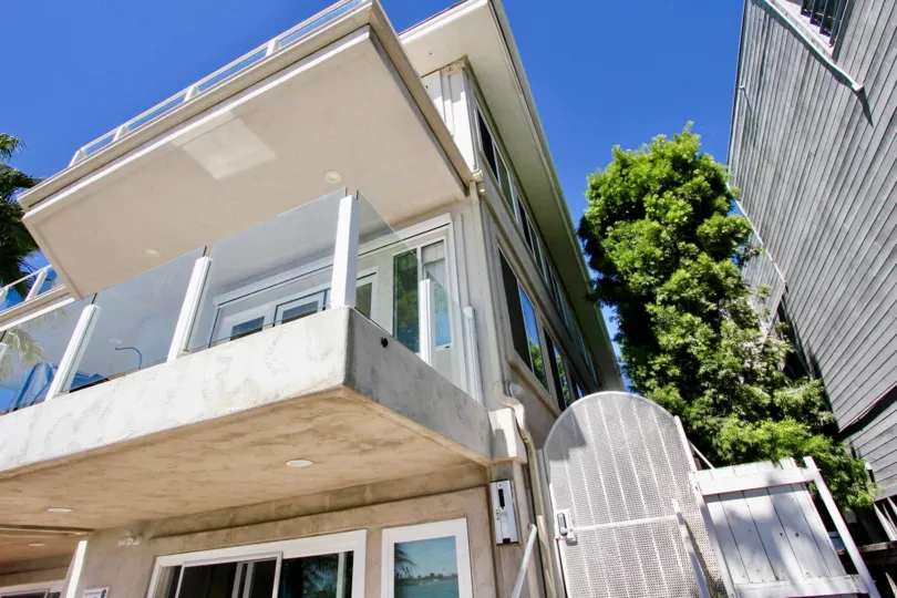 THE BUILDING IN THE SAIL BAY CONDOS WITH THE BALCONI, TREES, GATE