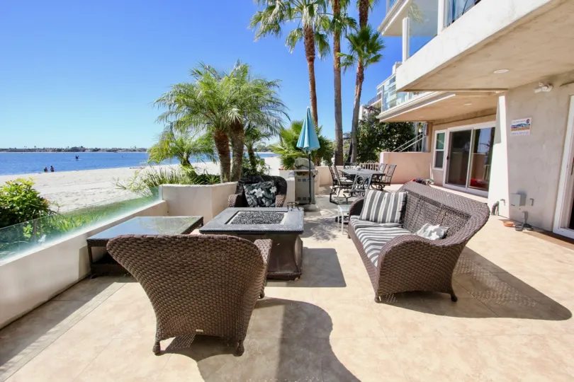 Patio of apartment building overlooking the water with patio furniture at Sail Bay Condos in Pacific Beach, Ca