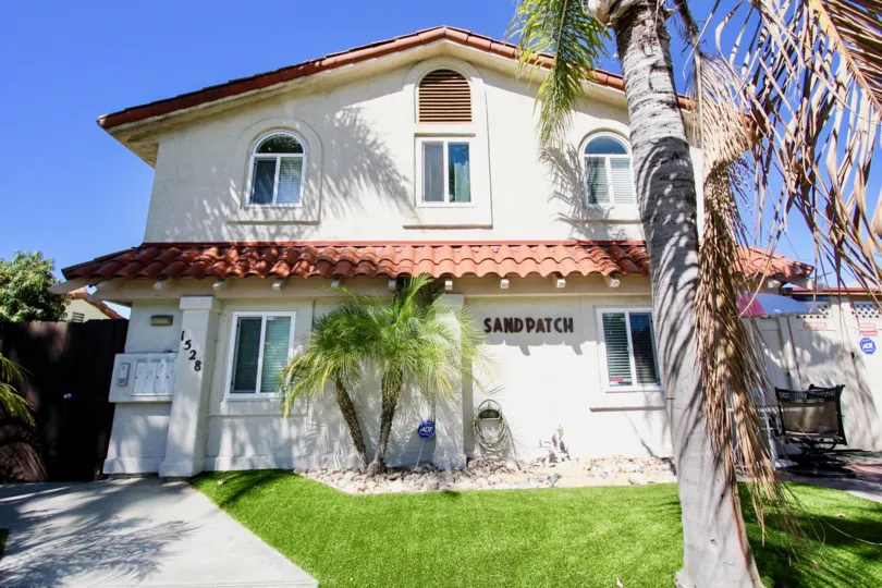 A sunny day in the area of Sand Patch, outside, house, palm trees, grass, driveway, hose