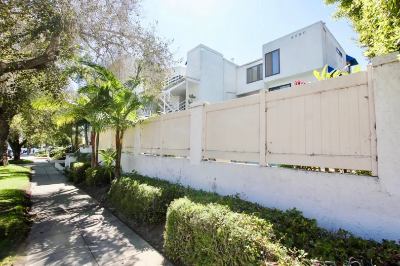 A sunny day in the area of Santa Mariana, outside, trees, condos, sidewalk, privacy fence