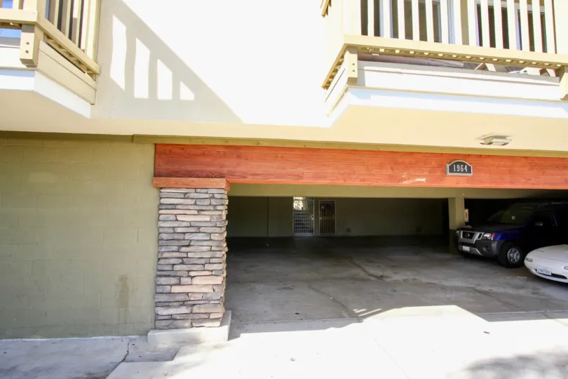 Parking garage in Pacific Beach, California with two parked cars and balconies overhead