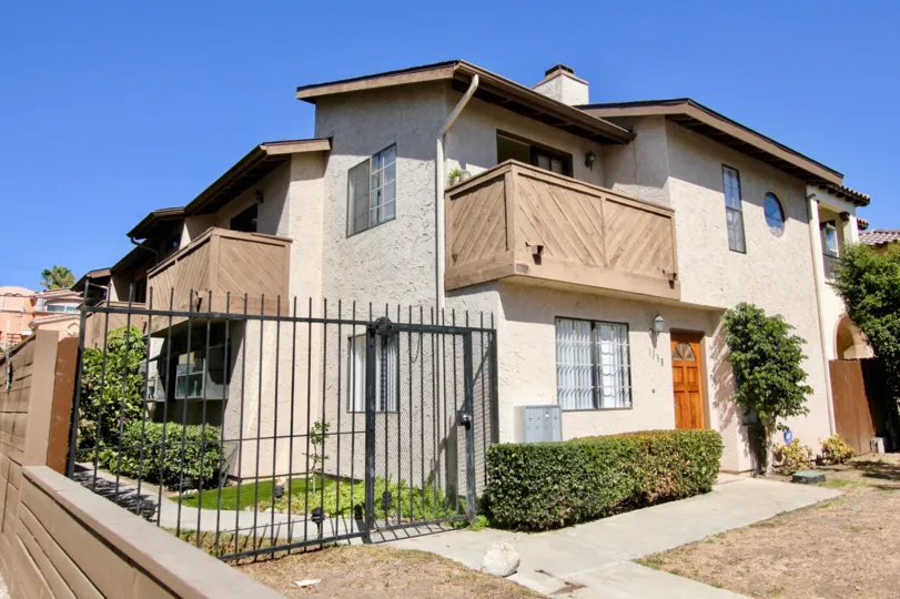 A sunny day in the Seaburst Townhomes community with apartments and a large black gate.