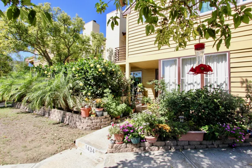 a sunny day in the thomas beach with building that has a lamp in the red colour and a small garden in front