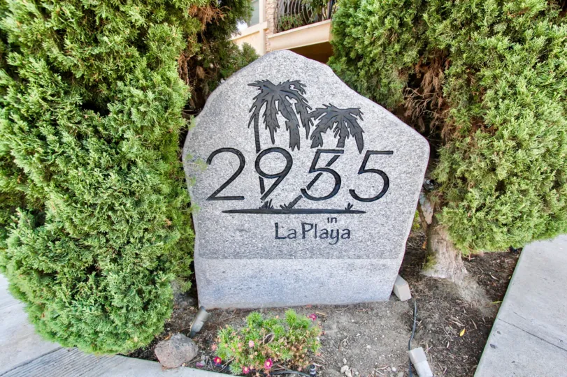 Large decorative address stone surrounded by well kept trees in Point Loma