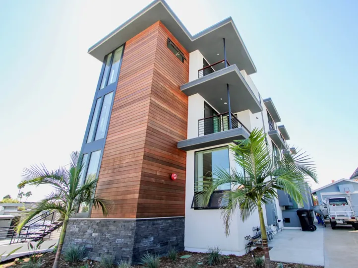 Modern exterior styling with wood siding and horizontal iron railings at the Carleton