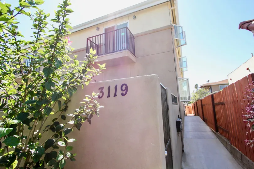 the back pathway of an apartment, with the unit number 3119, and a small plant in front, in Hugo Street Condos, Point Loma, California