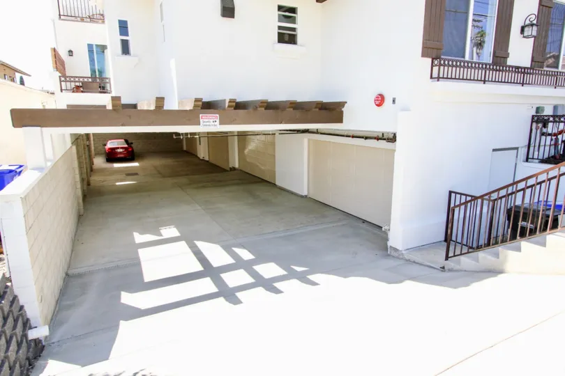 Underground parking entrance with overhead pergola and decorative shutters at Keats Place in Point Loma, CA