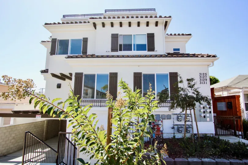 A crisp white Californian house with traditional shutters on a sunny day