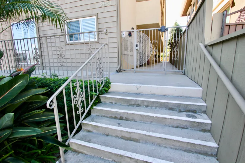 Small stairs leading to balcony with door and gated path, located in La Playa Bayshore, Point Loma, California.