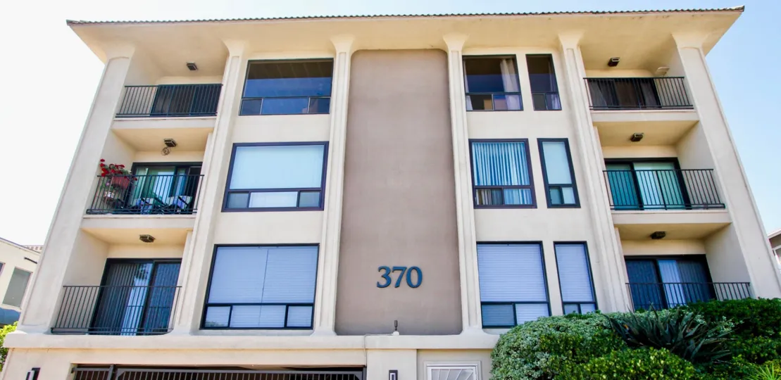 A grouping of bushes sit under a balcony at La Playa towers