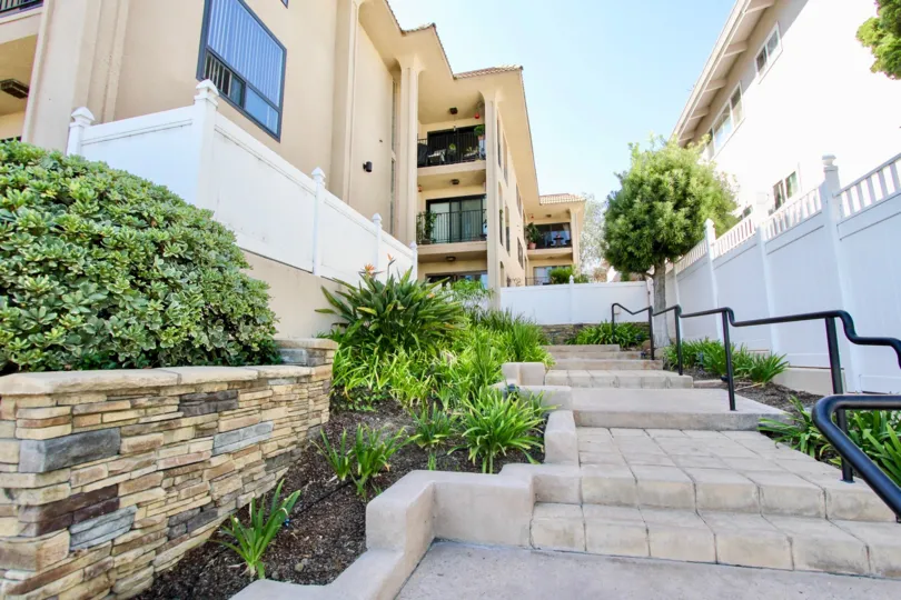 Brick steps with black railing lined with plants at La Playa towers in Point Loma CA