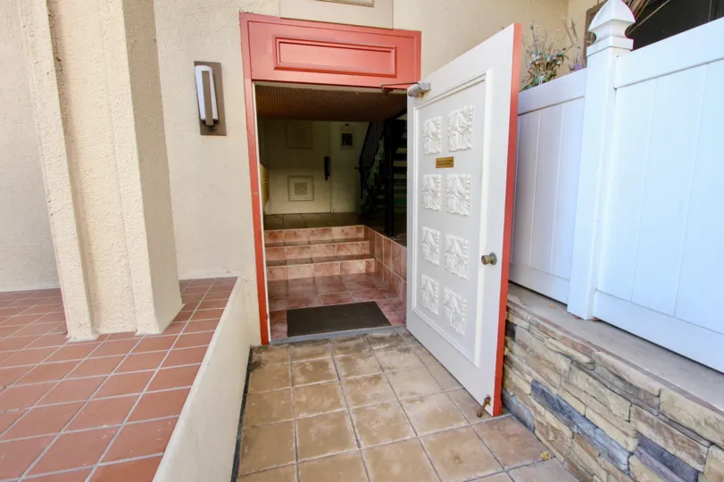 An open ornate red and white door leads to a stairwell in at LaPlaya Towers condos