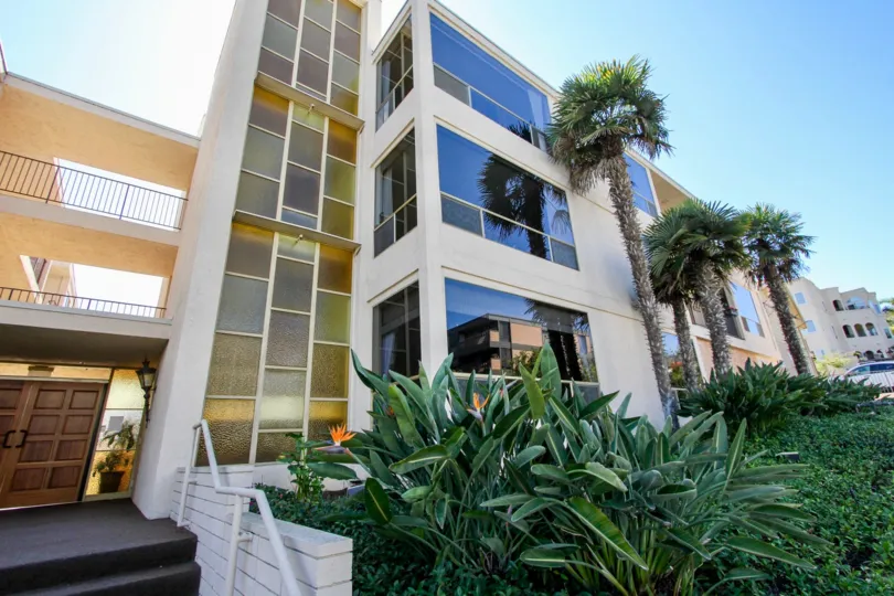 A three story condominium building with a glass wall at Park La Playa in Point Loma CA