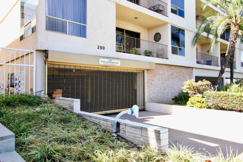 The shaded parking garage entrance of the apartment buildling located at 390 San Antonio Ave