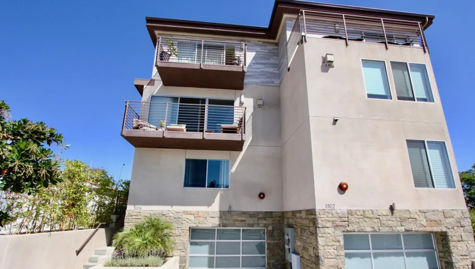Single car garage units with glass doors and modern iron railings and multiple balconies in Point Loma