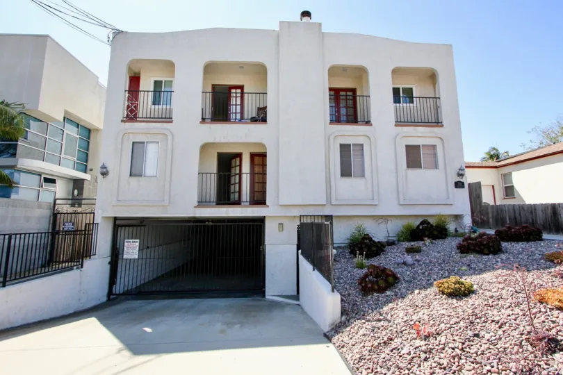 A white low-rise residence in the Primrose Gardens community with no lawn.
