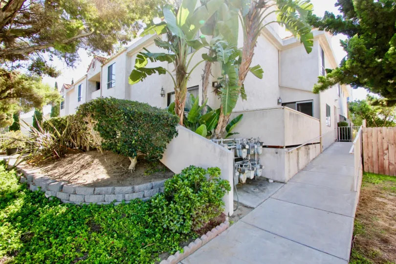 A long sidewalk leads to a white gate at Roseville Terrace condos