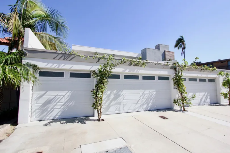 Two thin trees rest between garage doors at Vista Del Bahia condos