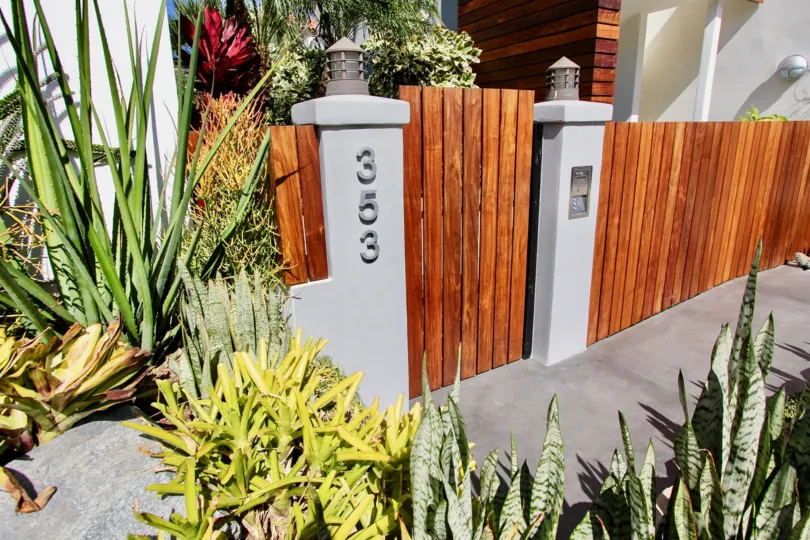 Sunny day outside of 335 in Vista Del Bahia community featuring landscaping and gate