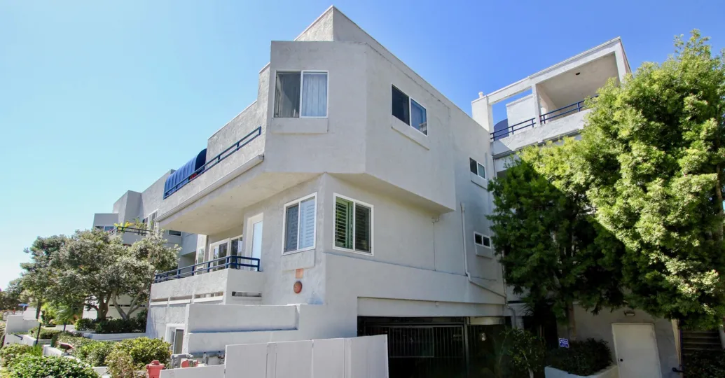 three story white condominiums with dark parking area inside vista la playa at point loma ca