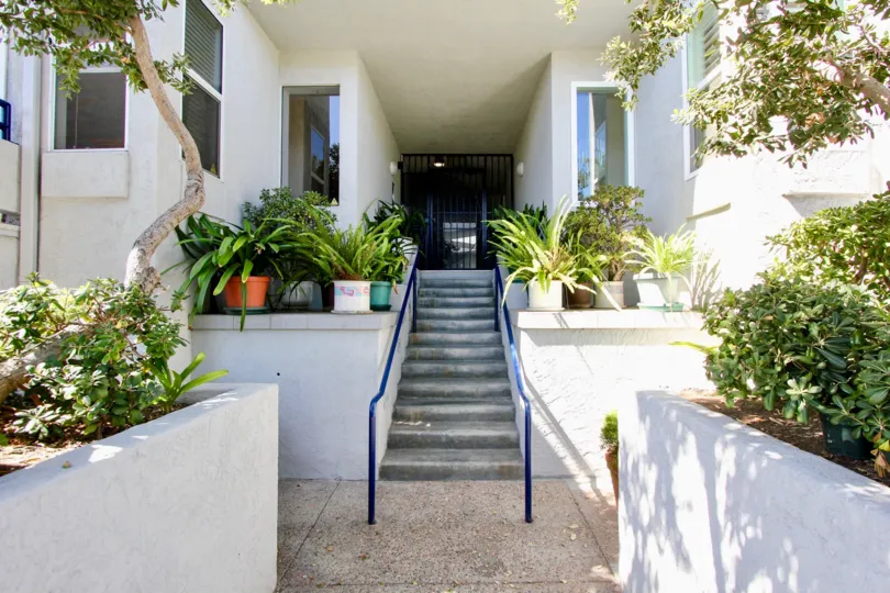 A SUNNY DAY IN THE VISTA LA PLAYA WITH BUILDING ENTRANCE AND SOME TREES, PLANTS