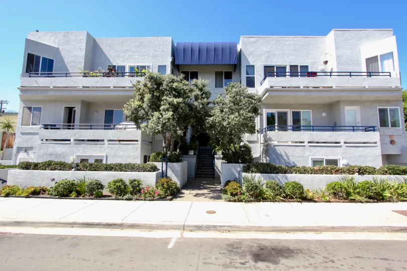 Entrance decorated with trees, plants and flower in front of the building in Vista La Playa