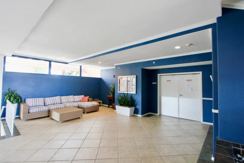 Blue interior of modern lobby with couch and white double doors in Yacht Club Condos