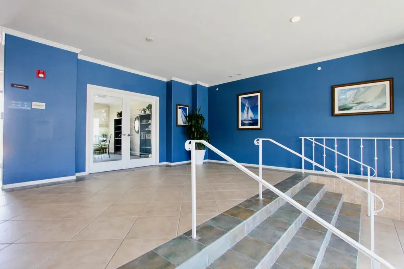 Nautical themed entrance foyer with framed art and tile floors at Yacht Club Condos