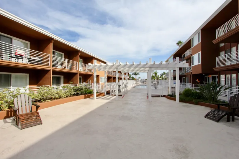 Large communal courtyard with pergola and fenced-in private swimming pool at the Yacht Club Condos