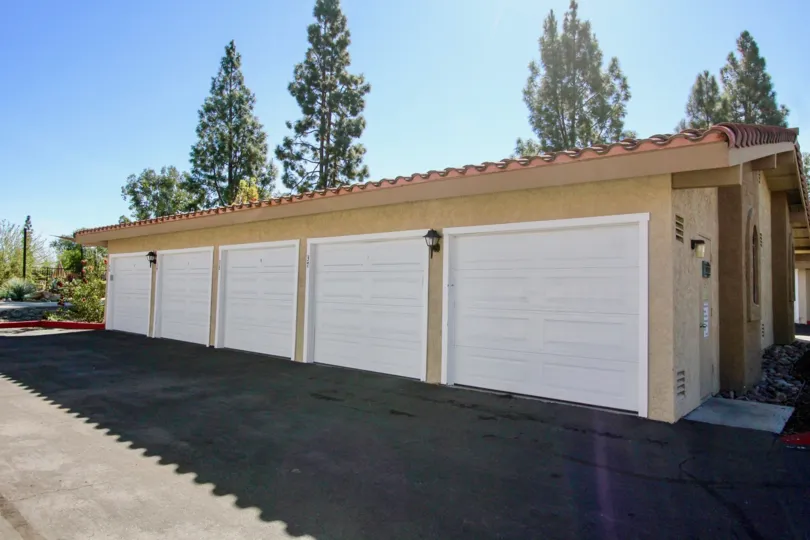 A row of garage doors with some trees in the back in Bernardo Greens, Rancho Bernardo, CA