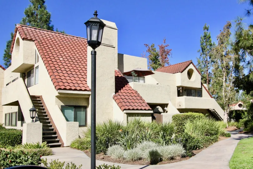 A house with red roof with some bushes and a lamp post in front at Bernardo Pines, Rancho Bernardo, CA