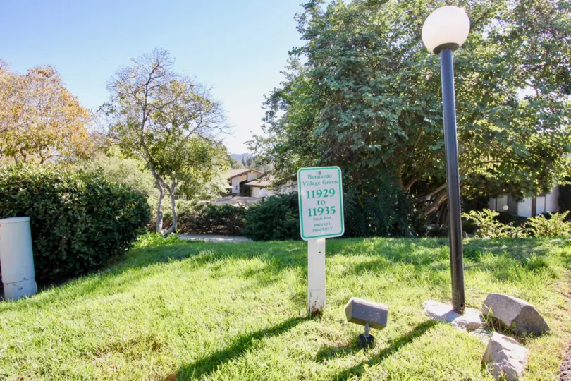 A hot day in Bernardo village Green has grass with lamp, rocks and board has declare as a private property