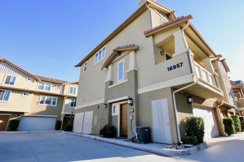 A house with a driveway in front and some bushes on the side during a sunny day in Bridgeport, Rancho Bernardo, CA