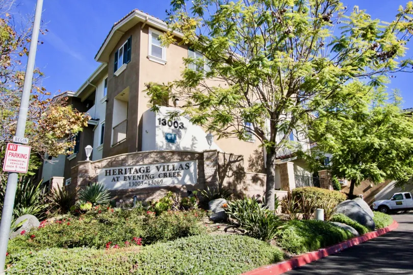 A corner with a house and a sign saying "Heritage Villas" and some trees during a sunny day in Heritage Villas, Rancho Bernardo, CA