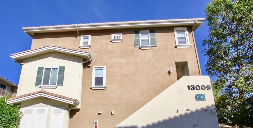 Stairway outside of a pink building with address at Heritage Villas in Rancho Bernardo CA