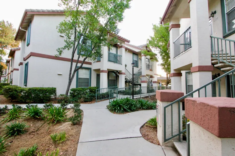 Some white and red houses with a bushy pathway in between in Hilltop, Rancho Bernardo, CA