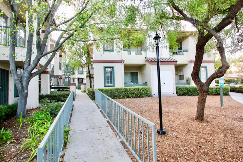 Long walk walk into what looks like a hotel property, lots of trees, shrubs and mulch