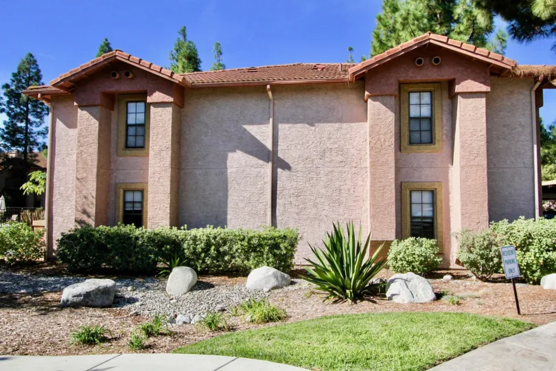 Two story pink building with plants and rocks at II Palio in Rancho Bernardo CA