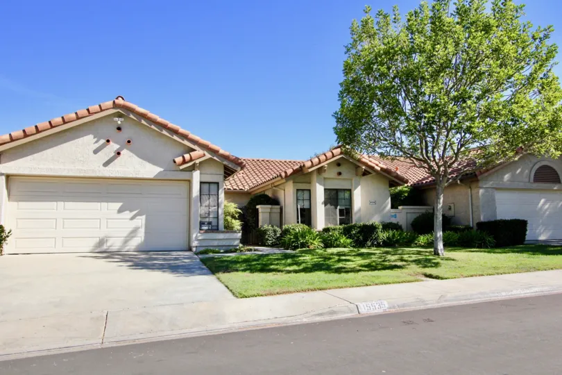 A white property with a garage and landscaping in Las Flores