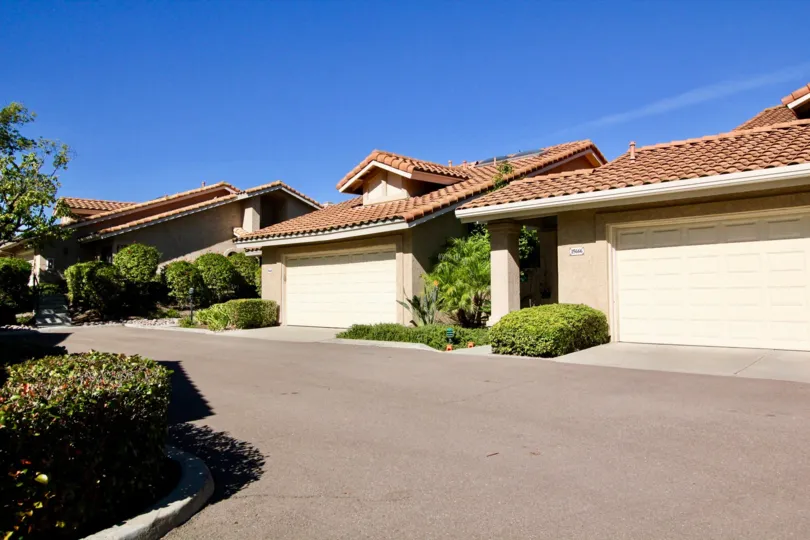 A sunny day on a street in the area of Las Flores, bushes, garages, street
