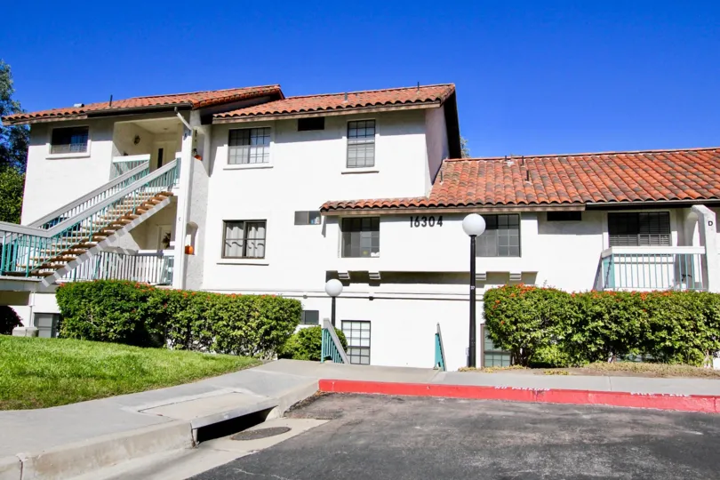 A white house with red roofing and some bushes in front at Mira La Paz, Rancho Bernardo, CA